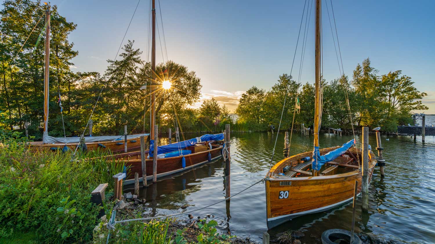 Segelboote am Ufer im Sonnenuntergang